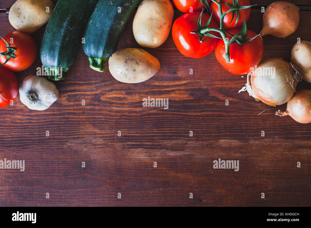 Frisches Gemüse auf hölzernen Hintergrund, Tomaten, Zwiebeln und Kartoffeln Stockfoto