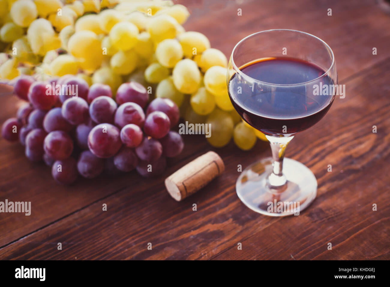 Glas Rotwein auf dem Tisch und Traubenmost Stockfoto