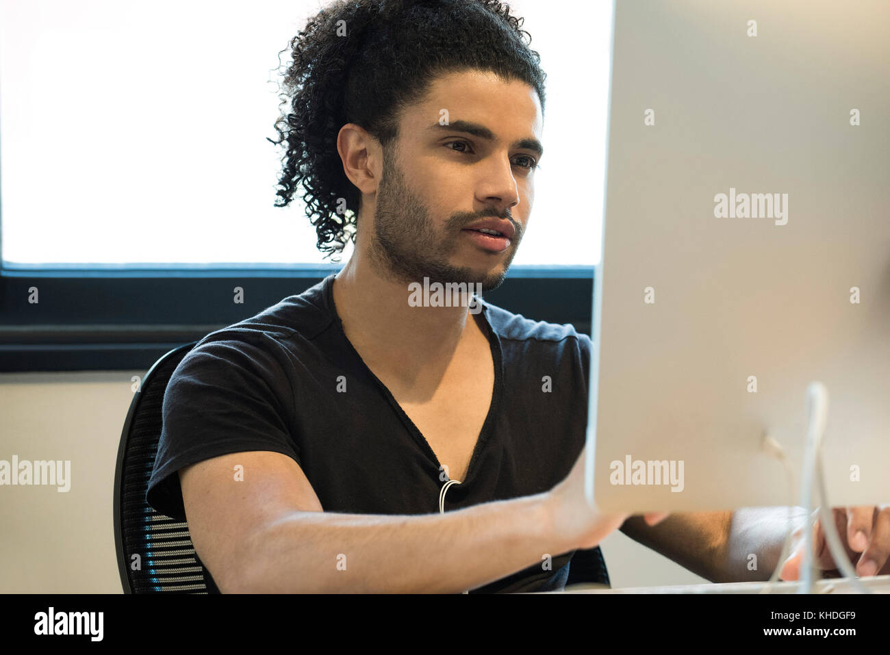 Junger Mann mit dem Desktop Computer Stockfoto