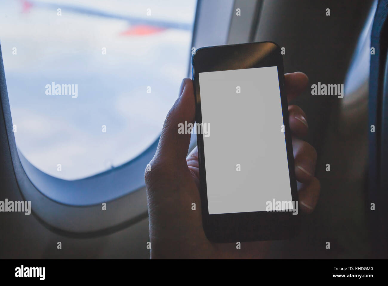 Hand smartphone Holding in Flugzeug, über Handy mit Leeren leeren Bildschirm in der Ebene Stockfoto