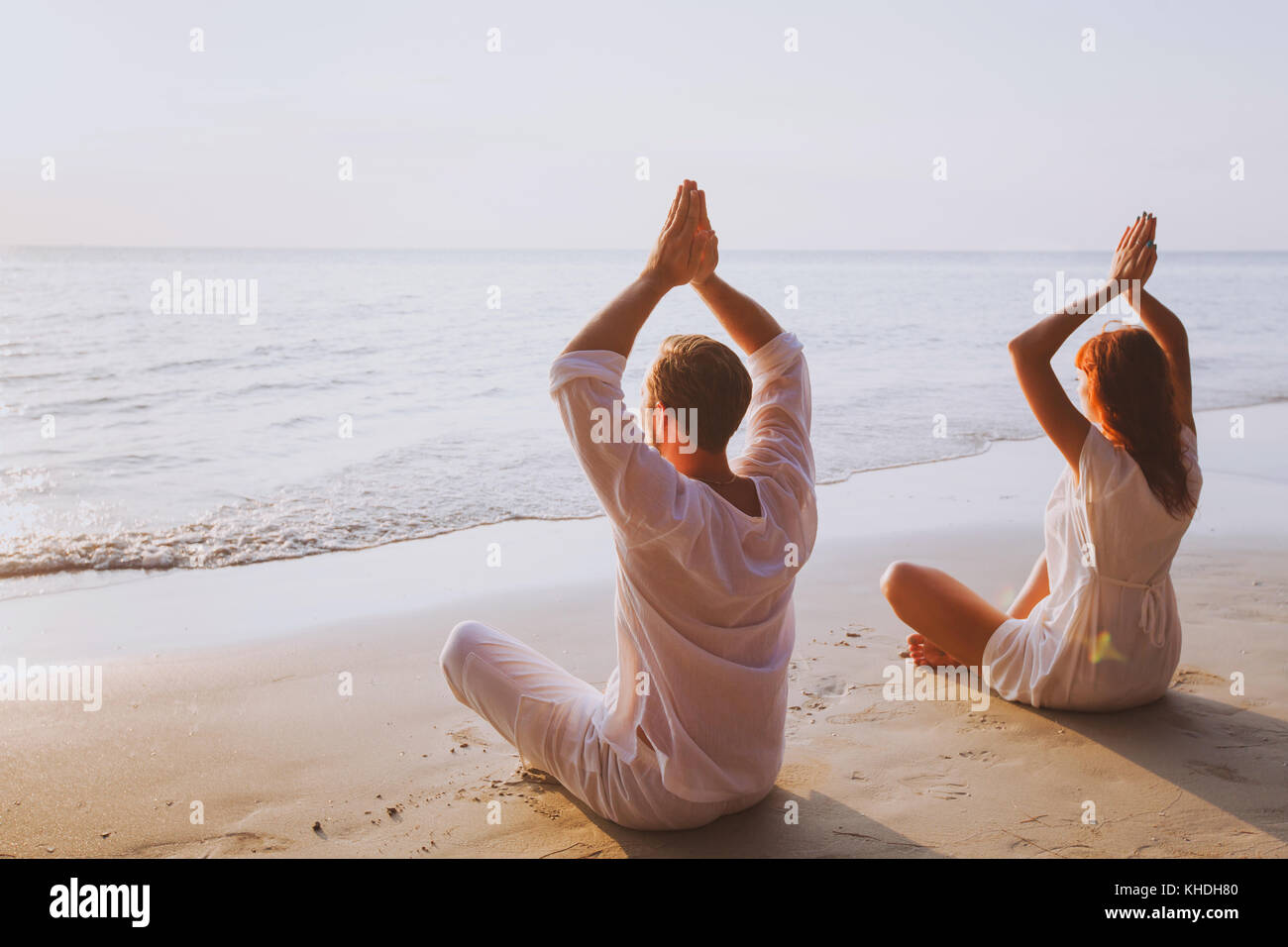 Gruppe Meditation, Yoga am Strand bei Sonnenuntergang Stockfoto