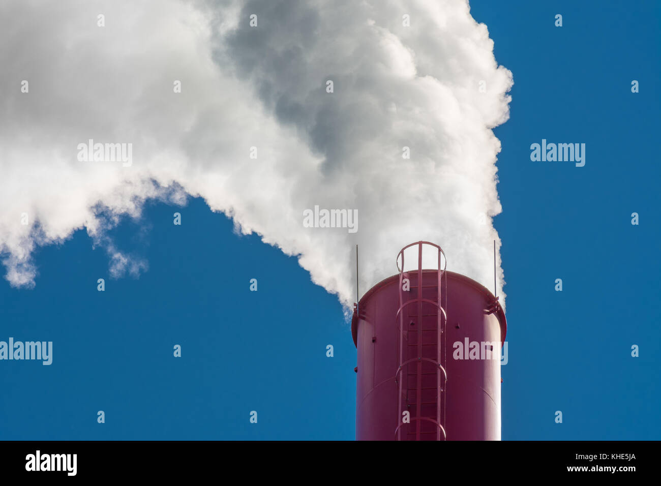 Red industrielle Schornstein. dichten weißen Rauch aufsteigend von hohen factory Schornstein am blauen Himmel. Stockfoto