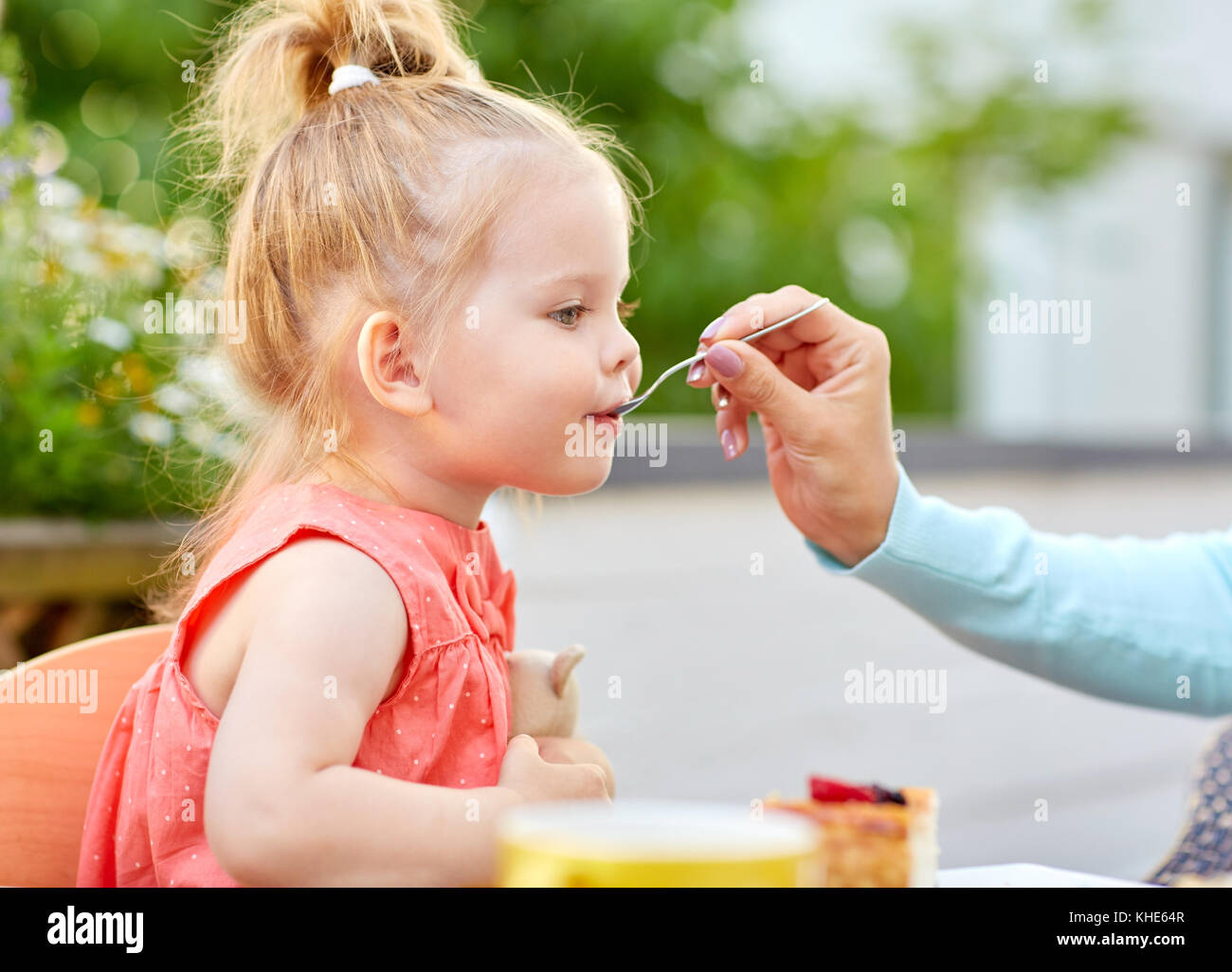 Mutter hand mit Löffel füttern Tochter im Cafe Stockfoto
