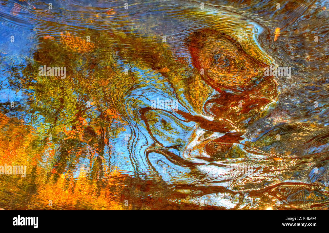 High Dynamic Range (HDR) Bild abstract der Blätter im Herbst und lebendige Farben in wirbelnden Wasser wider. Stockfoto