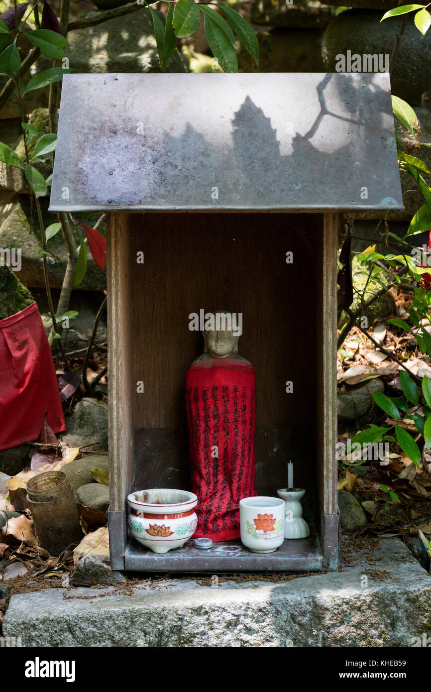 Iga Ueno-Japan, Juni 1, 2017: Traditionelle Stein gemeißelt jizo mit roten Rock geehrt und mit einer Tasse Wasser und Räucherwerk in Ueno Park eingehalten Stockfoto