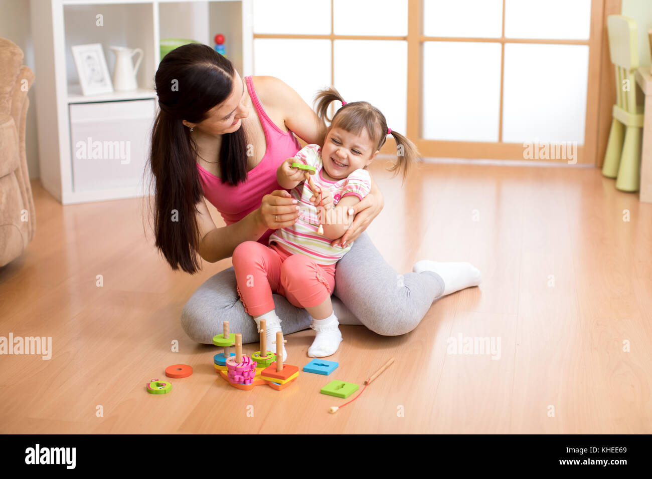 Mutter spielt mit Kind Tochter auf dem Boden Stockfoto