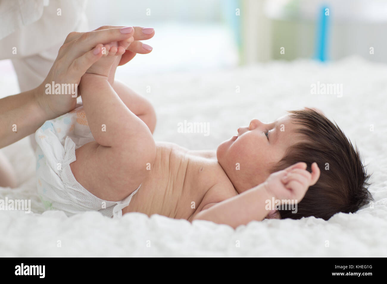Mutter hand massieren Bein und Fuß ihres Babys, Stockfoto