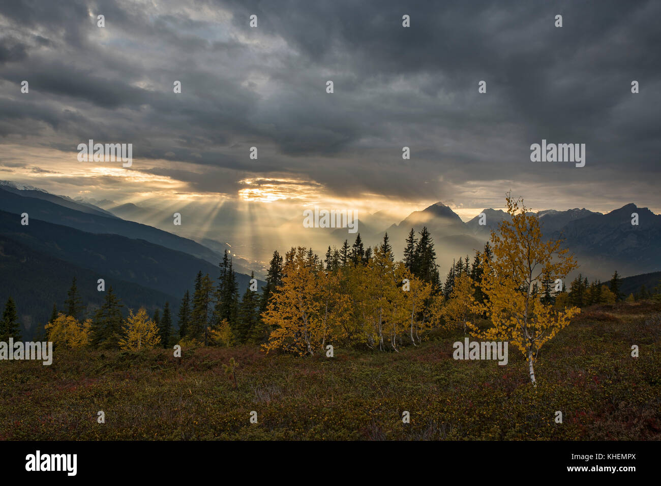 Berglandschaft im Herbst, Sonnenschein glänzt durch Bewölkung, Inntal, Tirol, Österreich Stockfoto