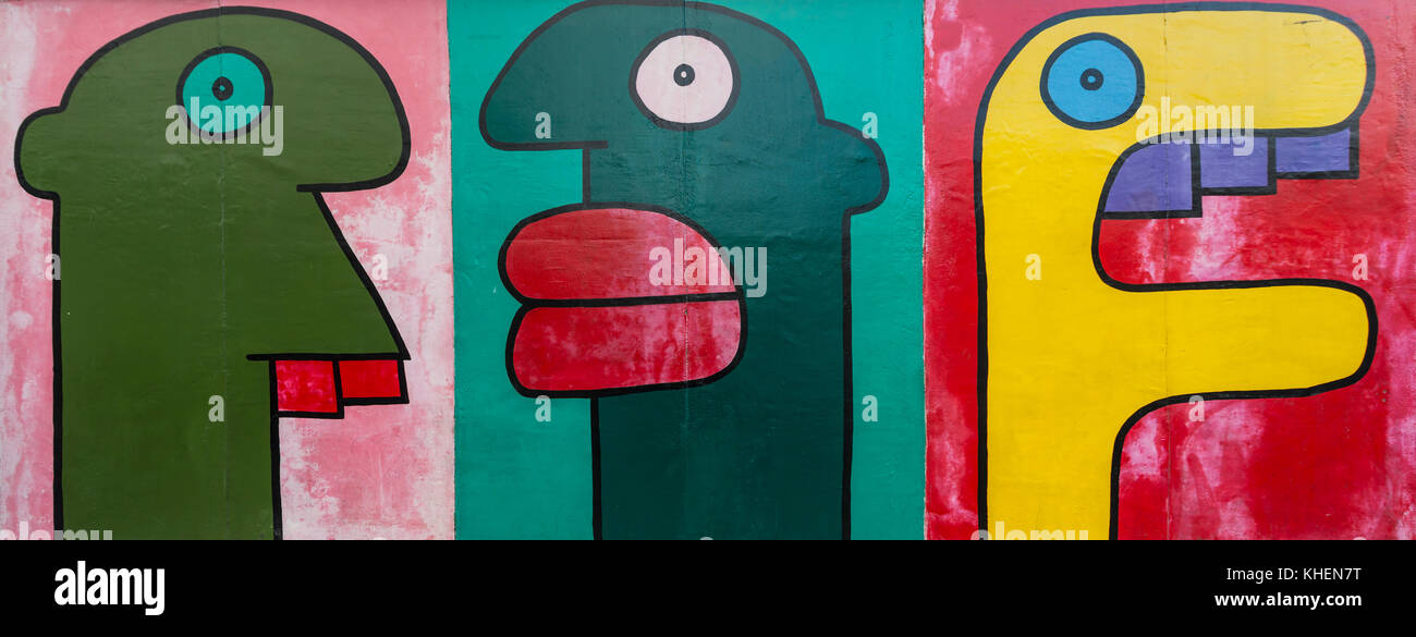 Bunte Köpfe im Comic-Stil, Gemälde an der Berliner Mauer, Künstler Thierry Noir, East Side Gallery, Berlin, Deutschland Stockfoto