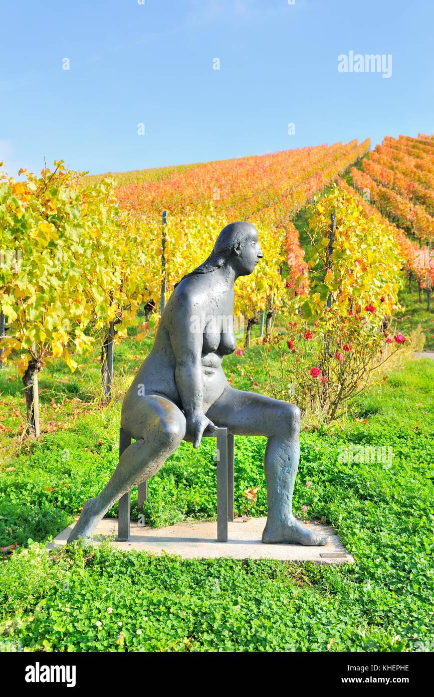 Sitzende Bronzeskulptur von Karl Ulrich Nuss vor den Weinbergen im Herbst, Skulpturenpfad Strümpfelbach, Remstal Stockfoto