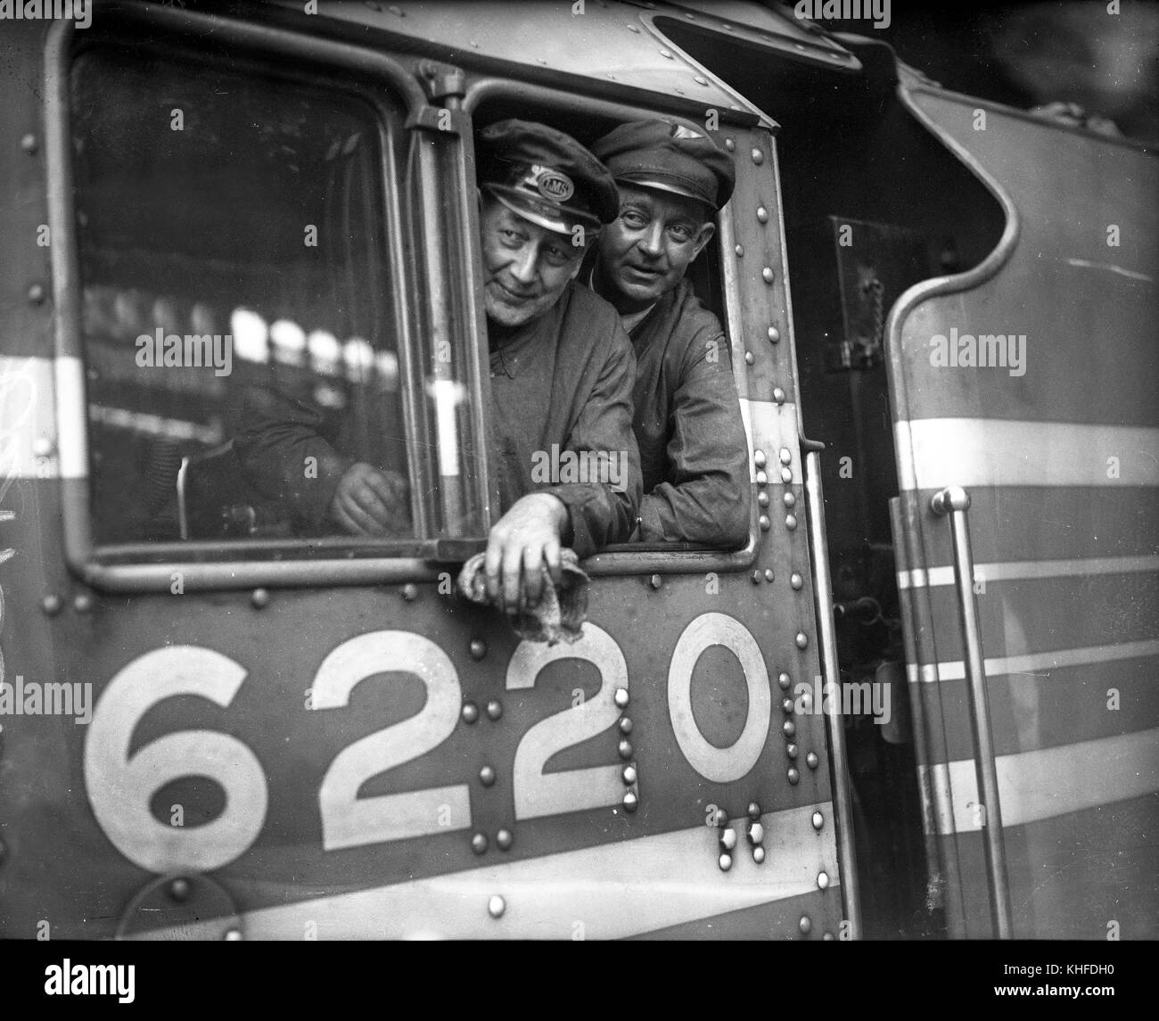 Rekordverdächtige Zugpersonal Treiber TJ. Clarke und Feuerwehrmann C. Lewis auf die Fußplatte der LMS Dampflok Prinzessin Krönung Klasse Nr. 6220 nach der Einstellung eines neuen Geschwindigkeitsrekord von 114 mph am 29. Juni 1937 Stockfoto