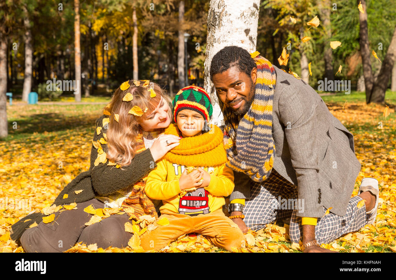 Glückliche Familie im Herbstpark. Afroamerikanische Familie: Schwarzer Vater, Mutter und Kind Junge über die Natur im Herbst. Stockfoto