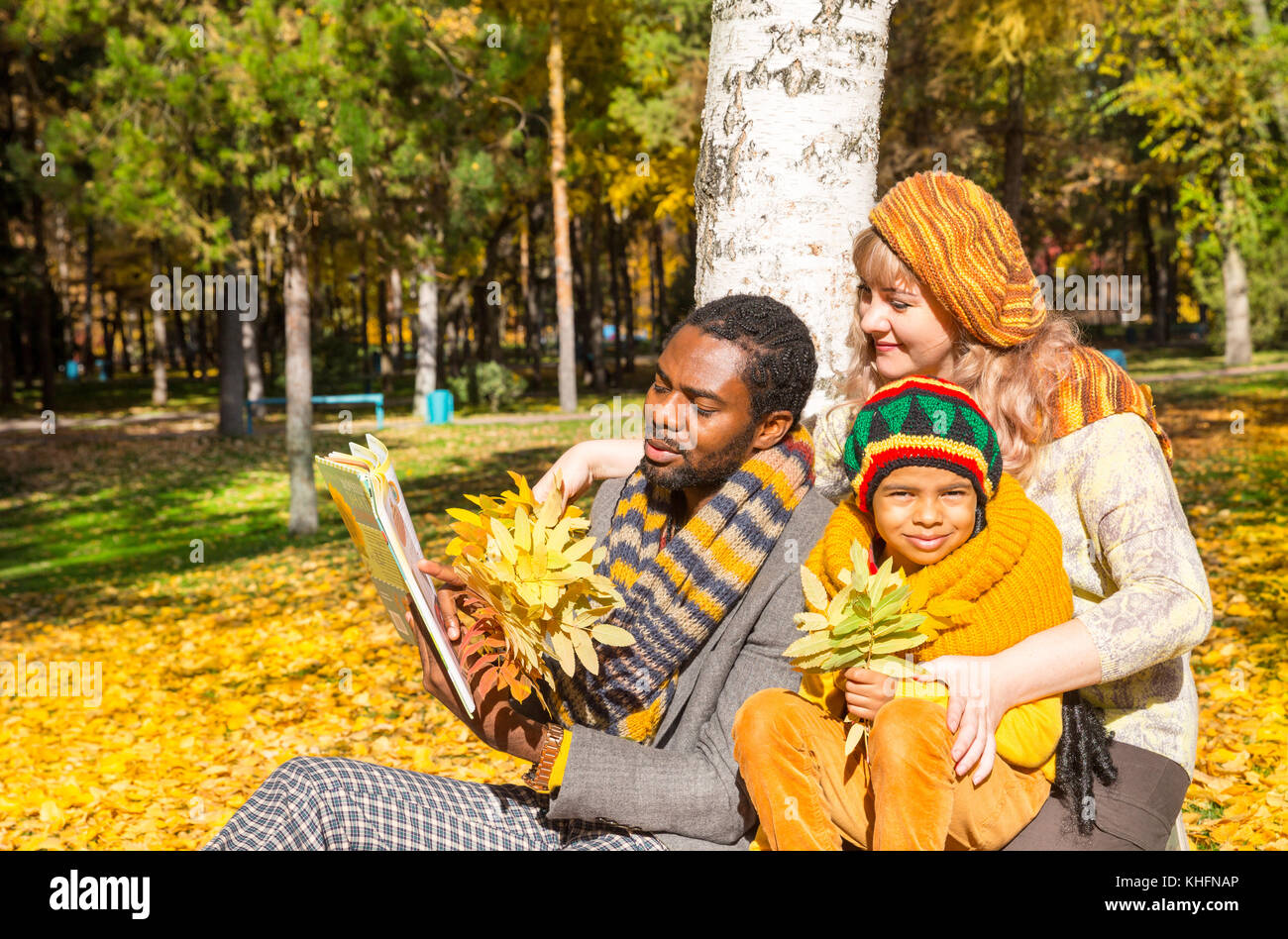 Glückliche Familie im Herbstpark. Afroamerikanische Familie: Schwarzer Vater, Mutter und Kind Junge über die Natur im Herbst. Stockfoto