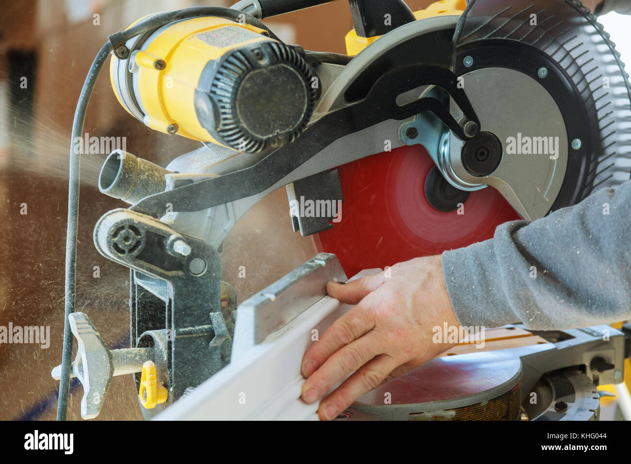 Hübscher junger Mann Tischler mit einer Kreissäge während der Installation von Holz im neuen Haus Bau Stockfoto