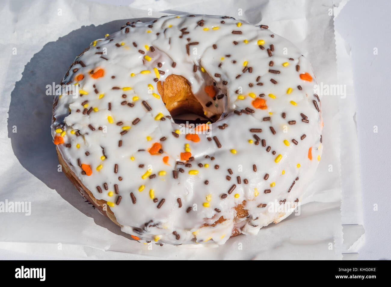 Große weiße iced Donut auf eine Papiertüte Stockfoto
