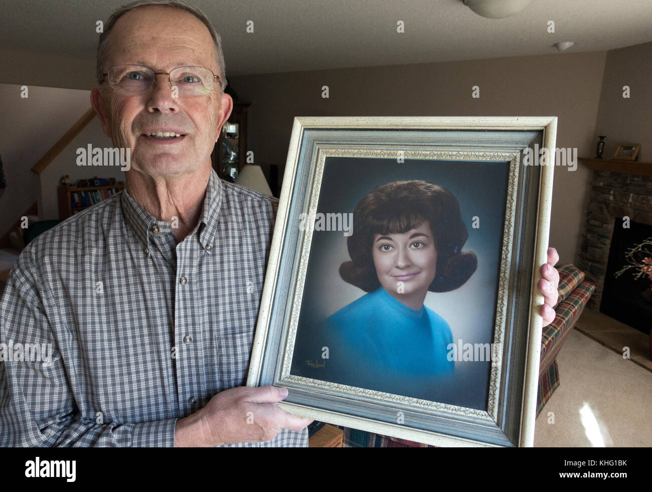 Lange Zeit Ehemann der verstorbenen Frau hält ihren High School portrait. champlin Minnesota mn Usa Stockfoto