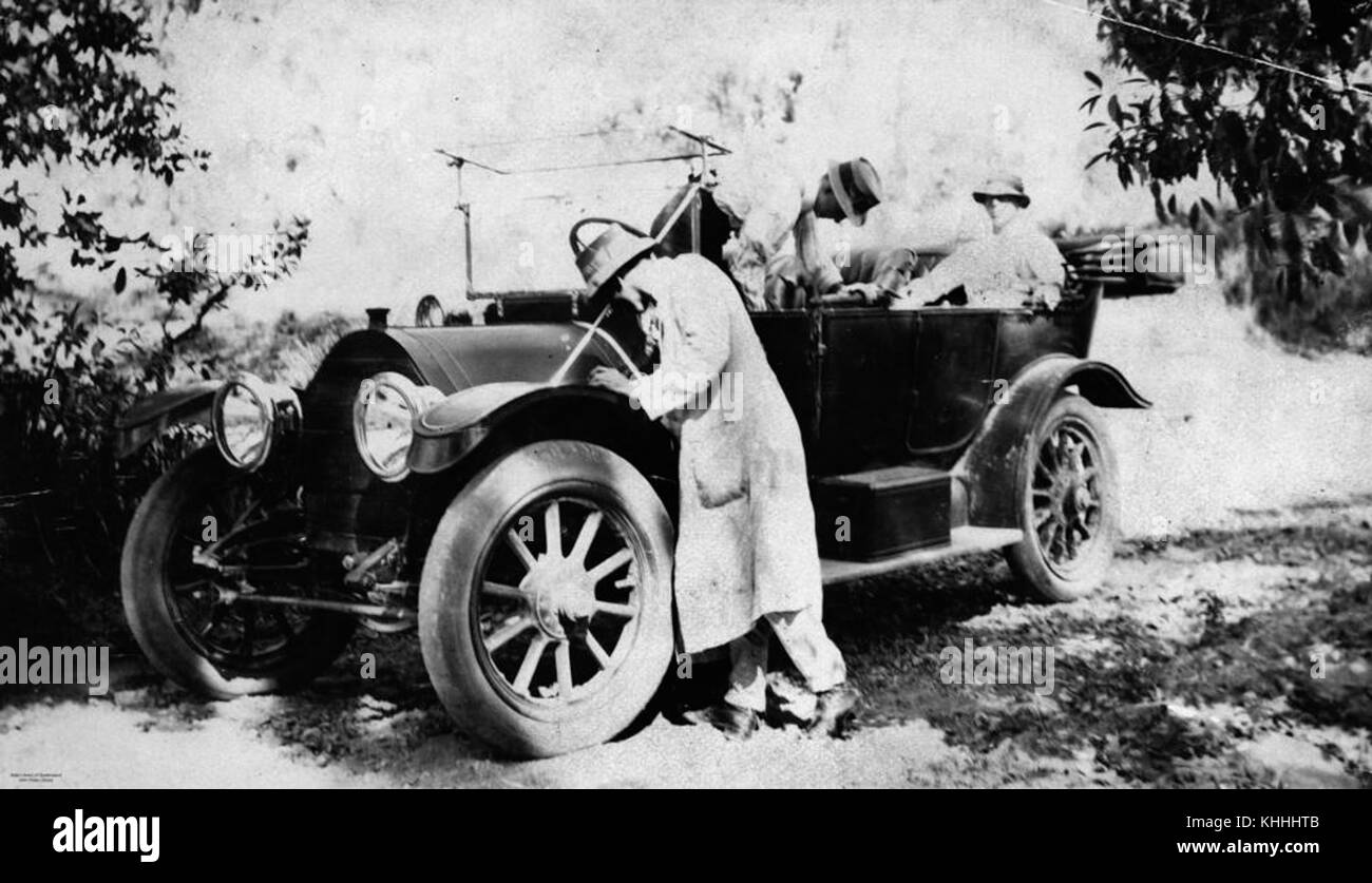 Diese historische Fotografie aus dem Jahr 1912 zeigt drei Männer, die ein Cadillac-Kraftfahrzeug betreuen. Das Bild zeigt die Anfänge der Automobilkultur und die Liebe zum Detail in der frühen Automobiltechnik. Stockfoto
