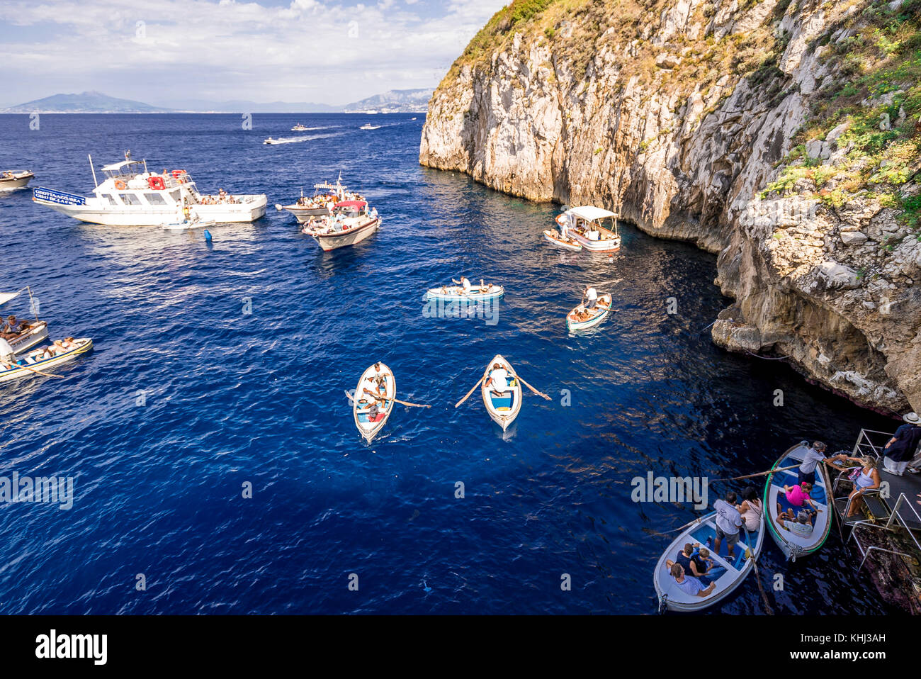 Eine Touristenschlange wartet in einem kleinen Boot auf die berühmte Blaue Grotte auf der Insel Capri in Italien Stockfoto
