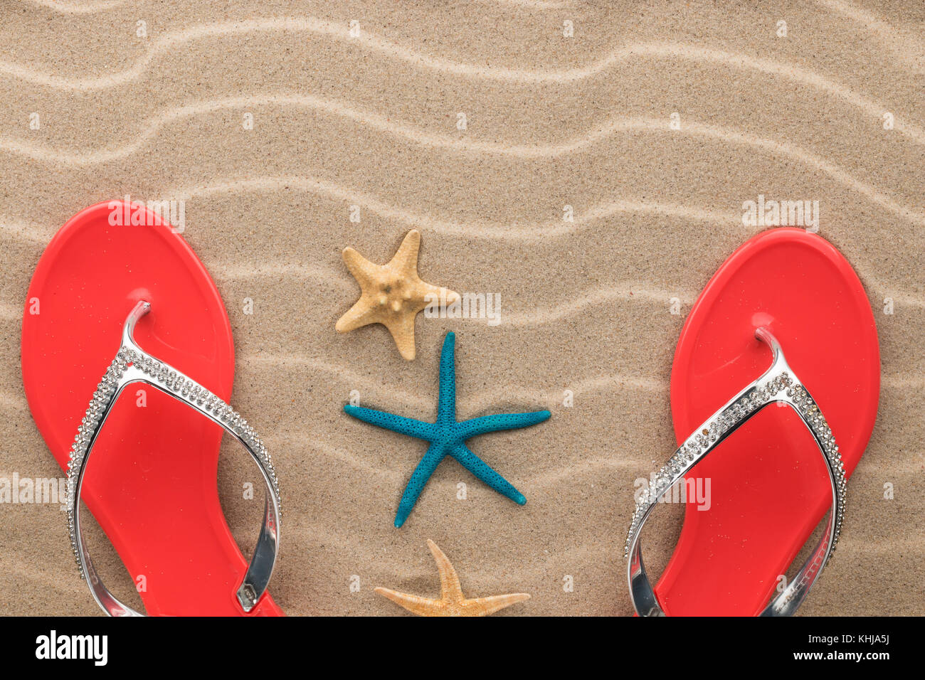 Beach Fashion, rosa Flipflops und Seesterne im Sand Strand. Mit Platz für Ihr Projekt Stockfoto
