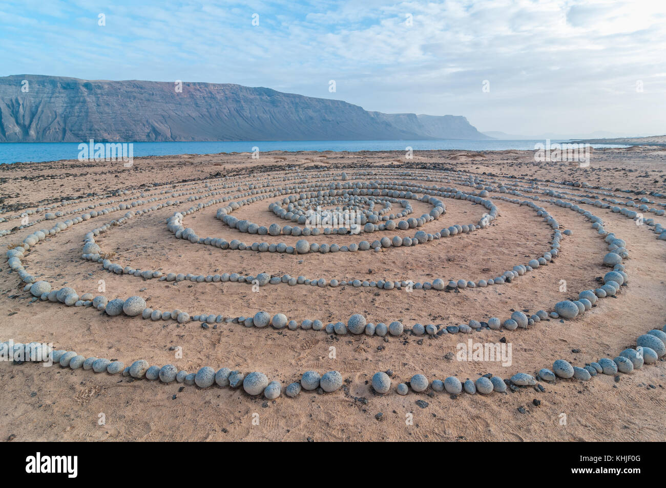 Runde Steine am Boden bildet eine Spirale, in der Nähe des Strandes, mit Lanzarote im Hintergrund, Caleta del Sebo, La Graciosa, Kanarischen Insel Stockfoto