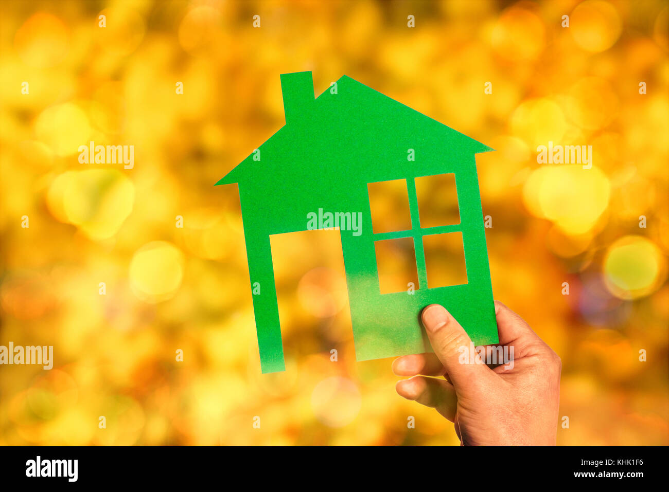 Grüne Silhouette eines Hauses vor einem unscharfen Hintergrund in warmen Farben mit Bokeh Stockfoto