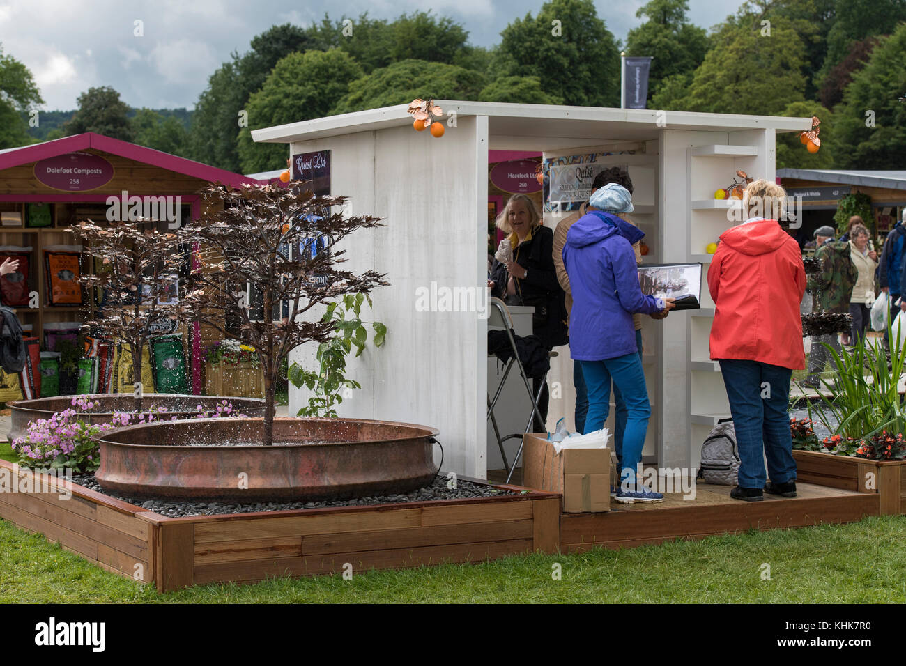 In der Nähe von Metall Skulptur Springbrunnen auf Quist Messestand mit Menschen arbeiten - RHS Chatsworth Flower Show Showground, Derbyshire, England, UK. Stockfoto