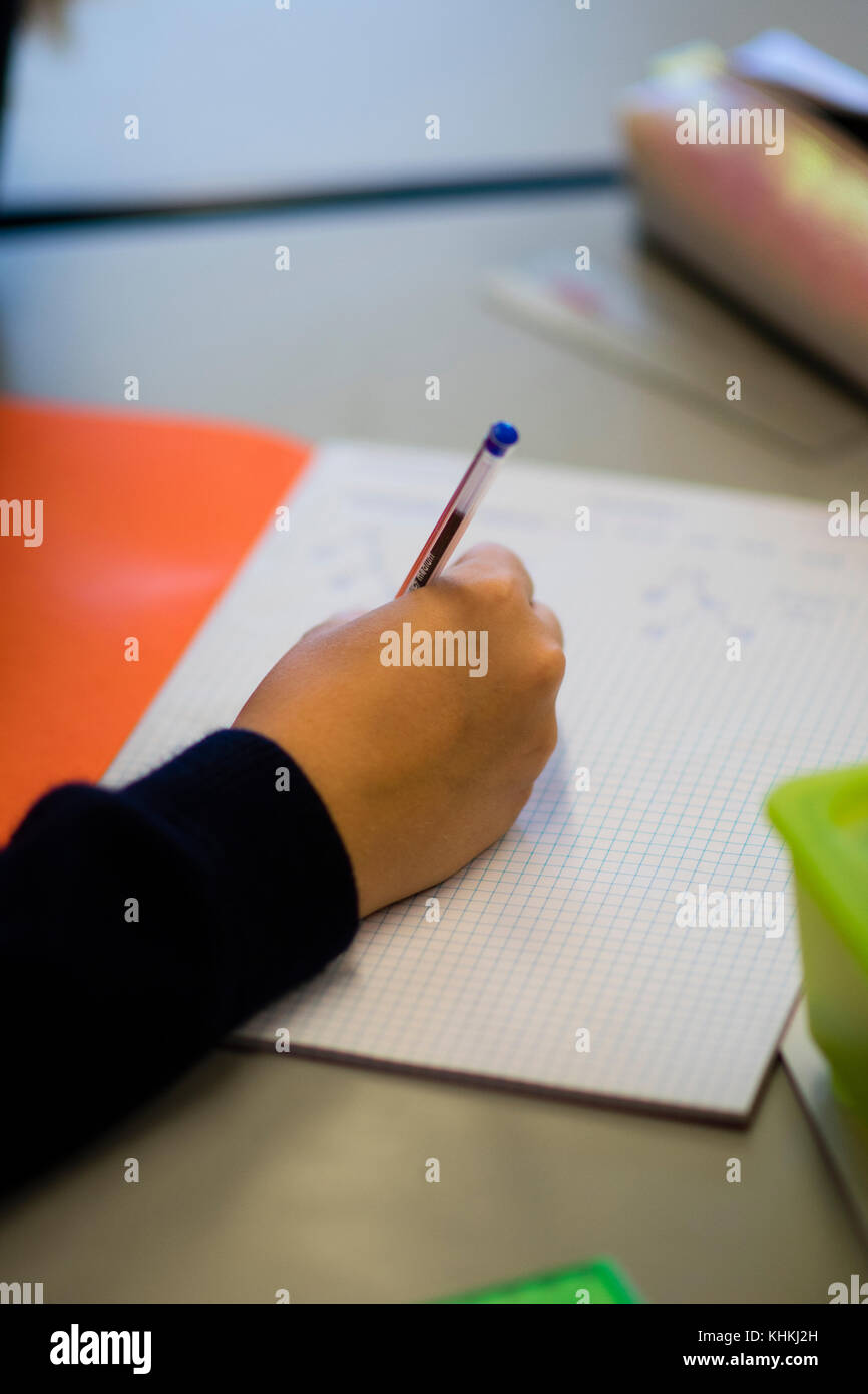 Sekundarstufe in Großbritannien: Nahaufnahme der Hand eines Schülers schreiben in ihr Schulheft beachten Sie Bücher in einer Mathematik Mathematik Mathematik Klasse Lektion Stockfoto