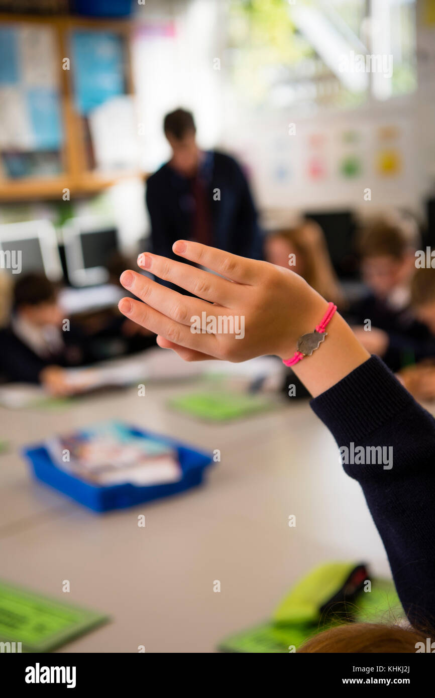 Sekundarstufe in Großbritannien: Nahaufnahme der Hand ein Schüler Fragen stellen oder Beantworten einer Frage in einer Lektion klasse Klassenzimmer. Stockfoto