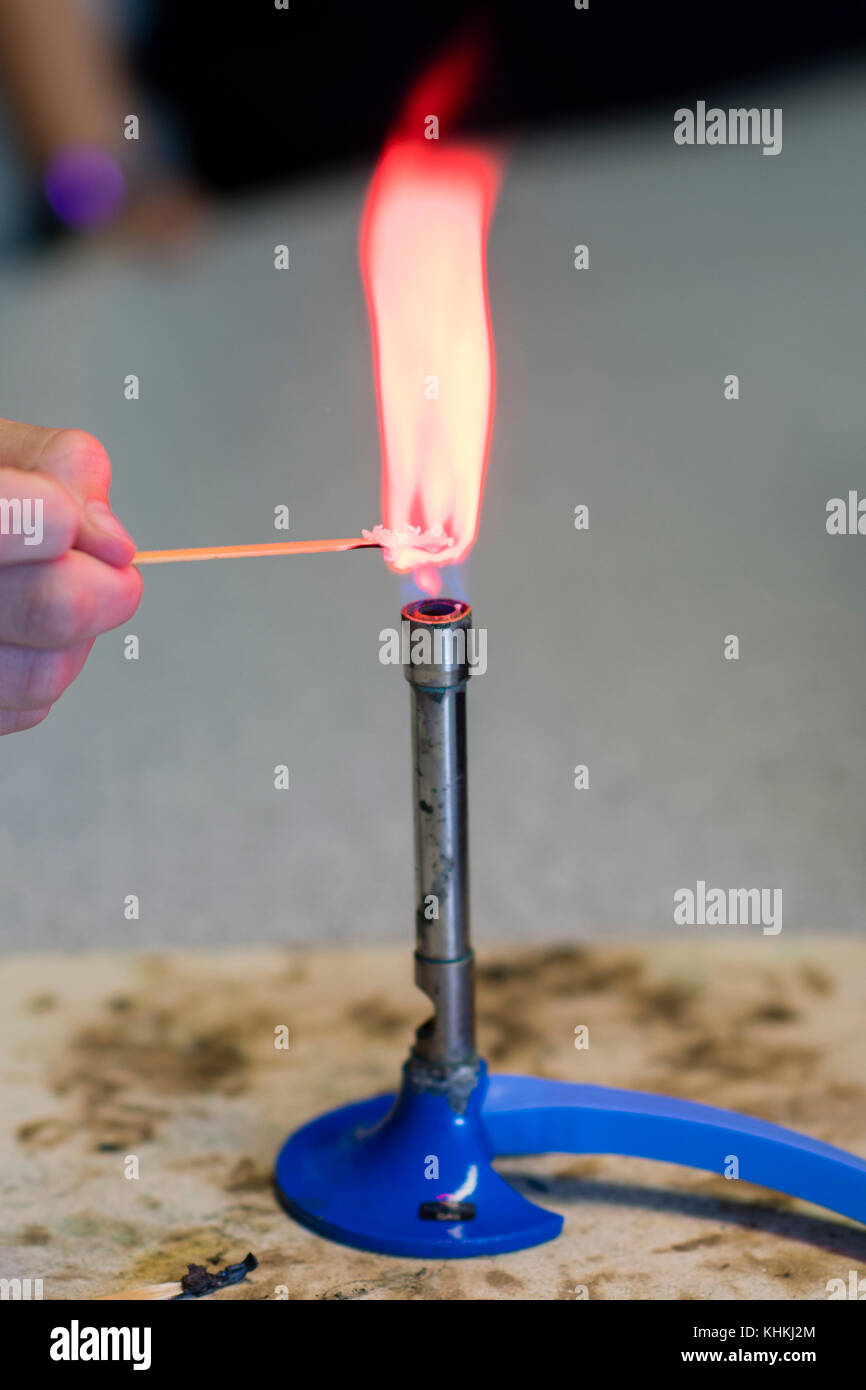 Sekundarstufe in Großbritannien: ein Schüler mit einem Bunsenbrenner in einem Chemie scicence praktische Lektion Klasse Stockfoto