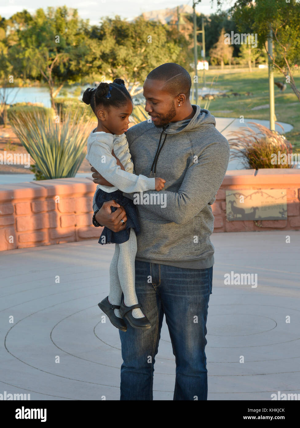 African American Dad Holding Tochter in einem Park. Stockfoto