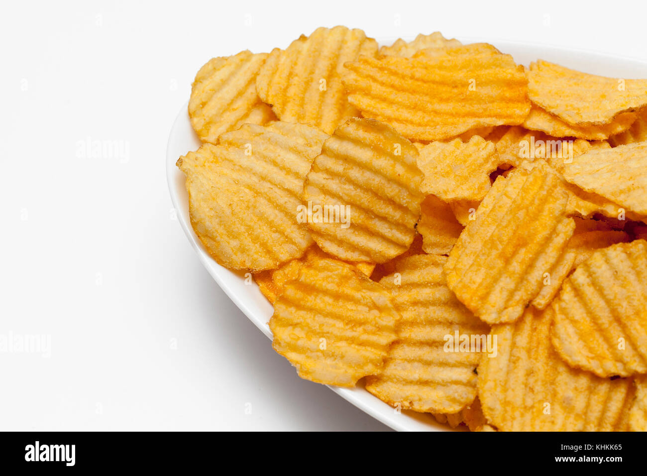 Gerippte Kartoffelchips mit Gewürzen auf weißem Hintergrund Stockfoto