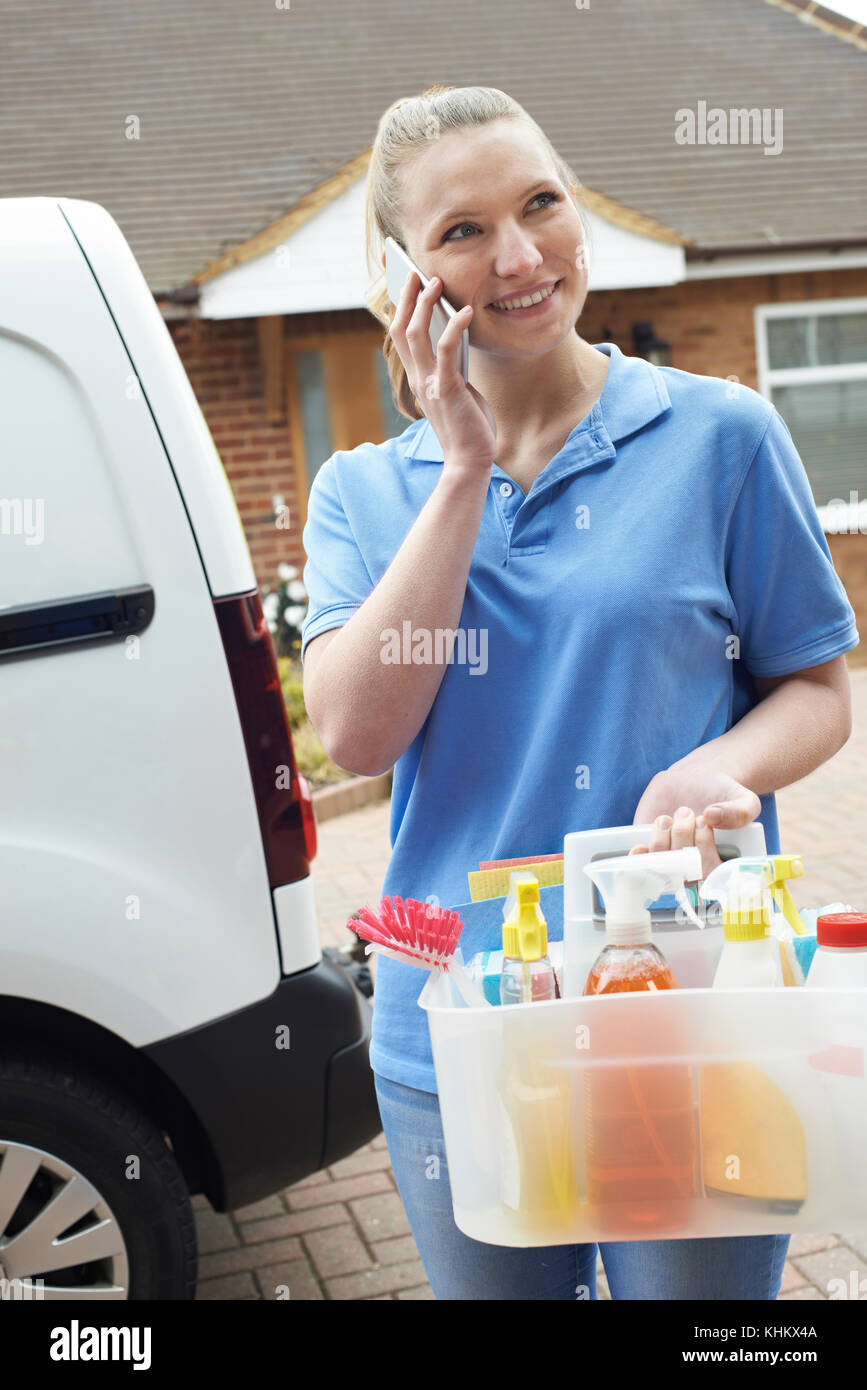 Junge Frau läuft mobile Reinigung Geschäft mit Van mit Handy Stockfoto