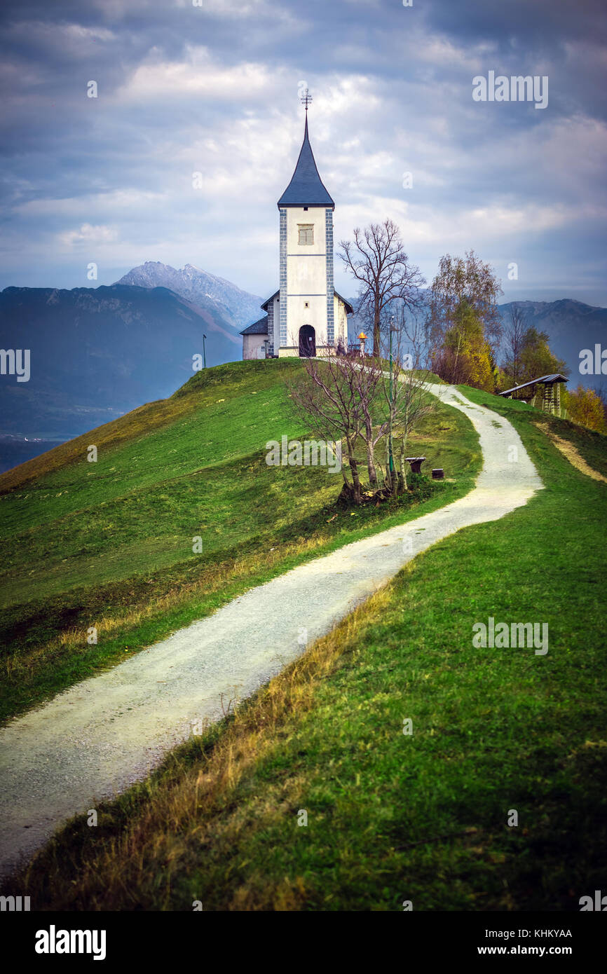 Jamnik, Slowenien - Die schöne Kirche St. Primoz in Slowenien bei Jamnik mit Julischen Alpen im Hintergrund Stockfoto