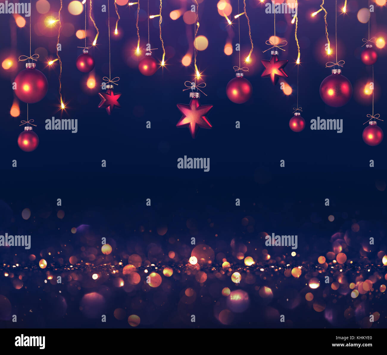 Kugeln und Weihnachtsbeleuchtung aufhängen auf dunklem Hintergrund Stockfoto