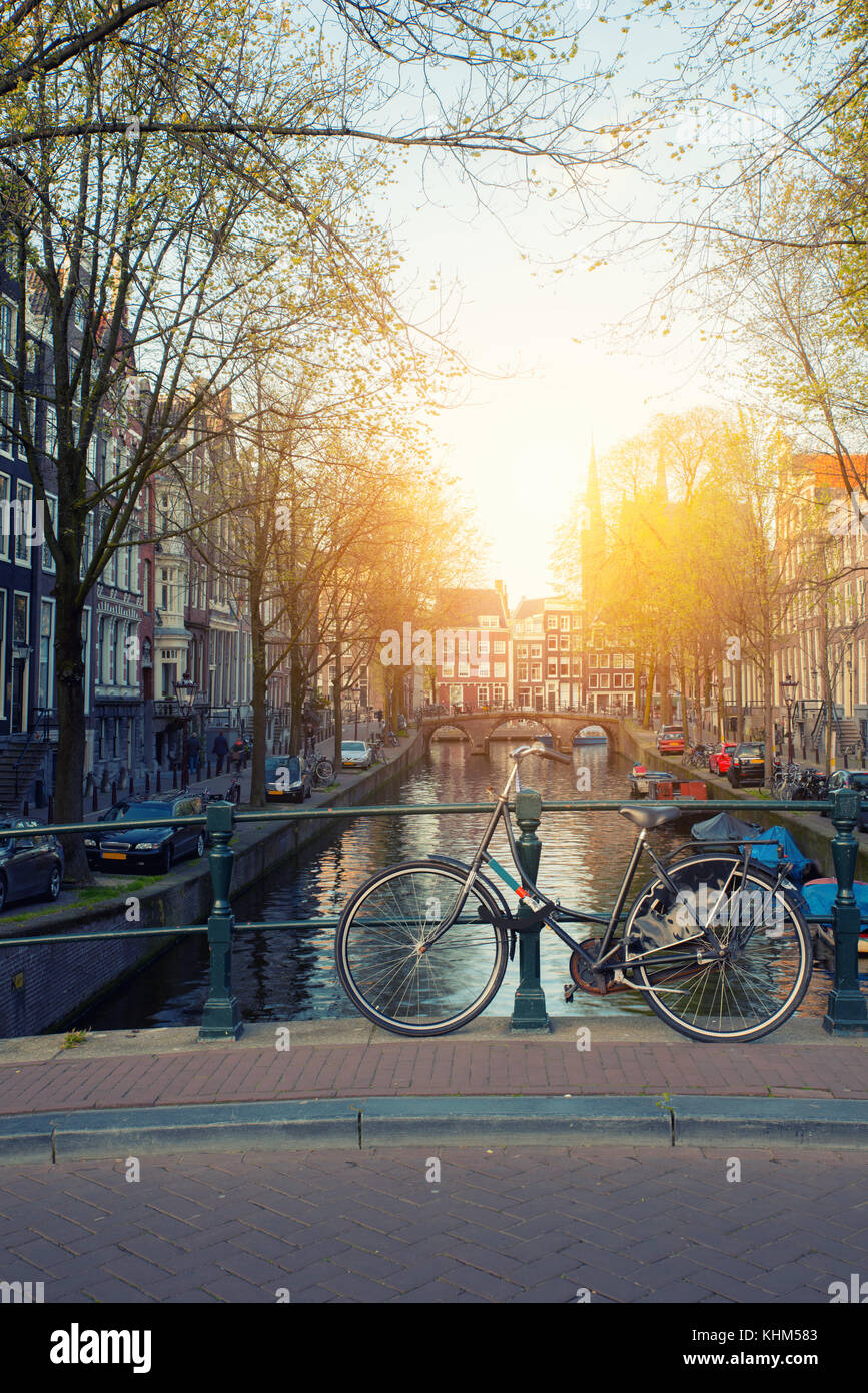 Fahrrad auf der Brücke mit Niederlande traditionelle Häuser und Gracht in Amsterdam in Amsterdam, Niederlande. Stockfoto