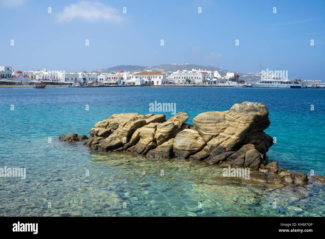 Fels im Meer, Aussicht auf den alten Hafen und Mykonos-Stadt, Mykonos, Kykladen, Ägäis, Griechenland Stockfoto