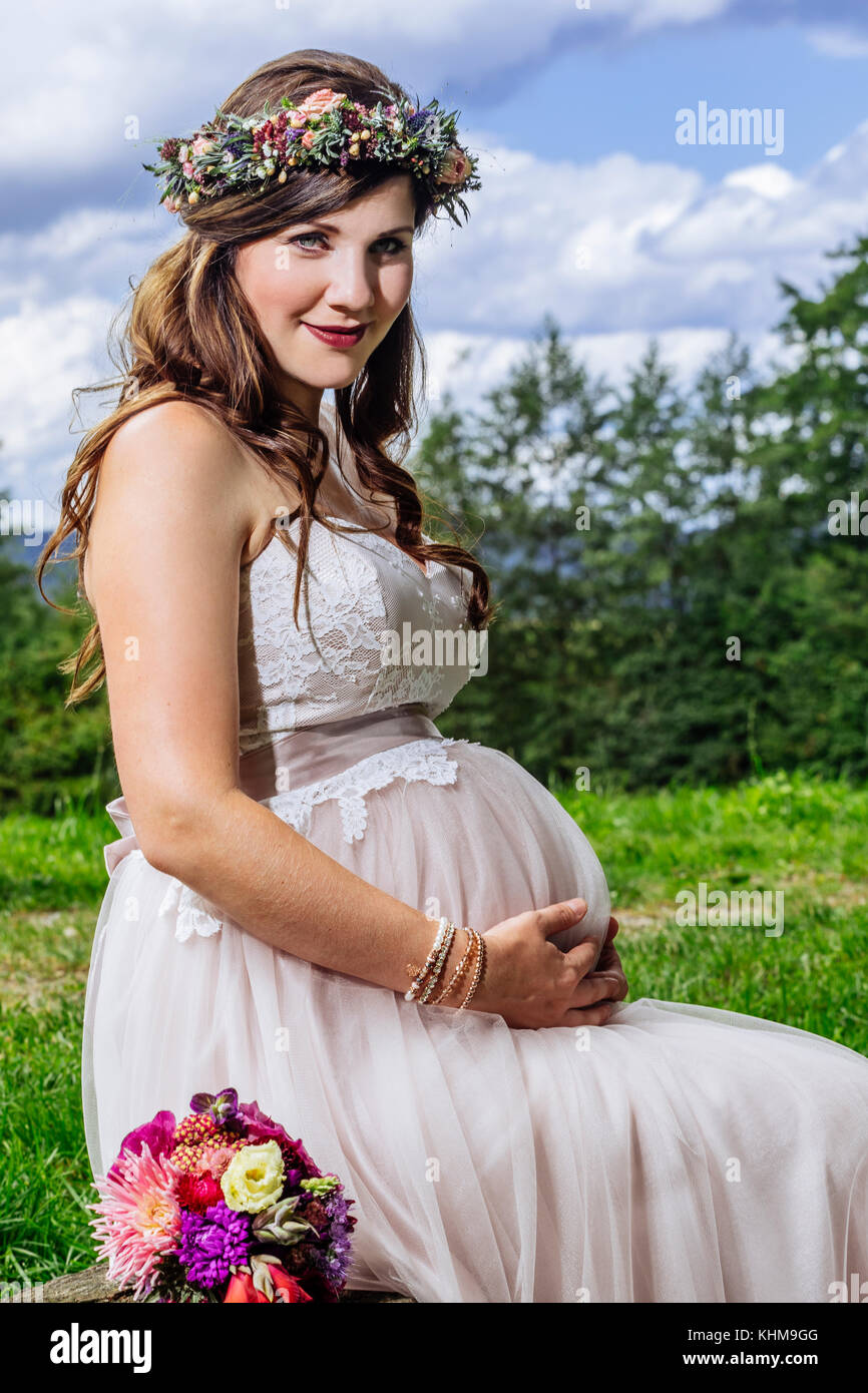Foto eines wunderschönen schwanger Braut auf einer Bank sitzen warten auf die Zeremonie zu starten. Stockfoto