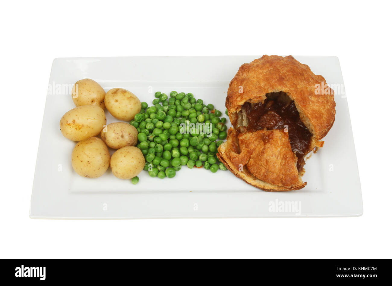 Steak pie neue Kartoffeln und Erbsen auf einer rechteckigen Platte gegen Weiße isoliert Stockfoto