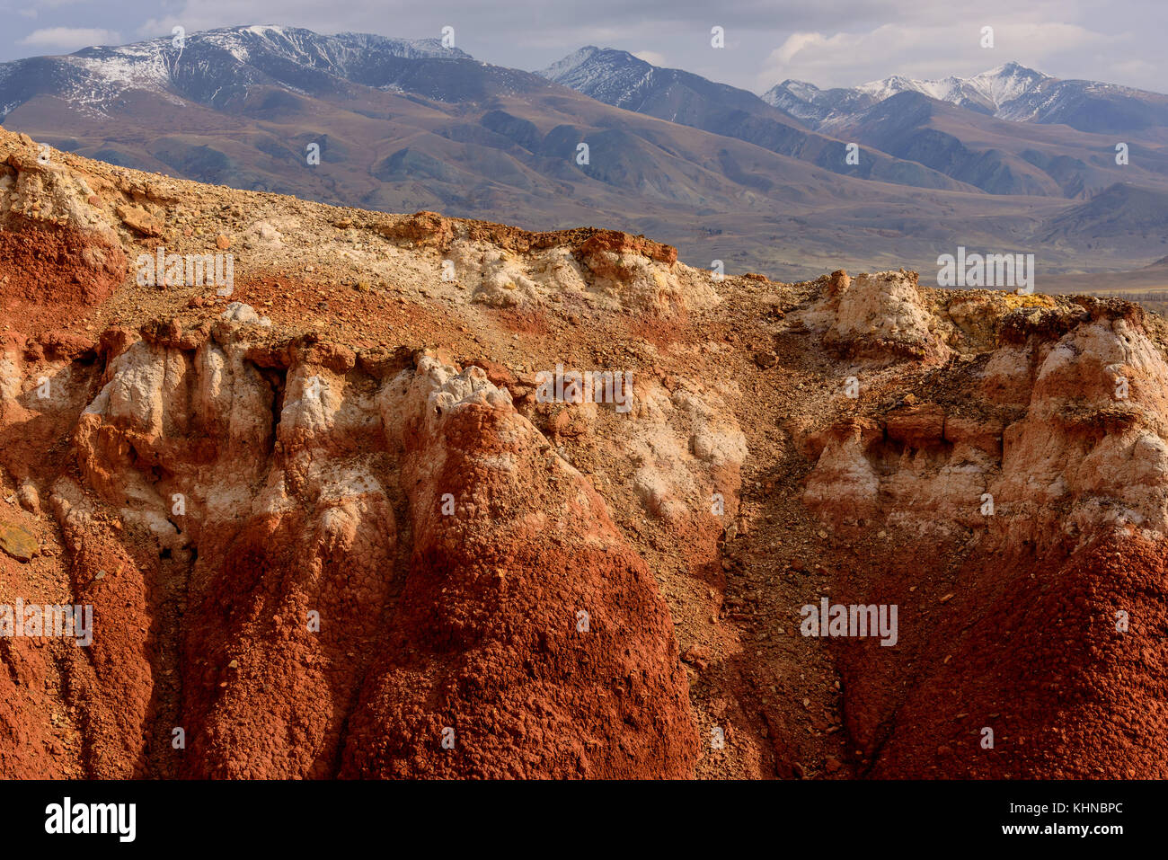 Die malerischen Steppe, Wüste Landschaft mit bunten Berge, Risse im Boden und spärliche Vegetation auf dem Hintergrund von anderen Bergen ein Stockfoto