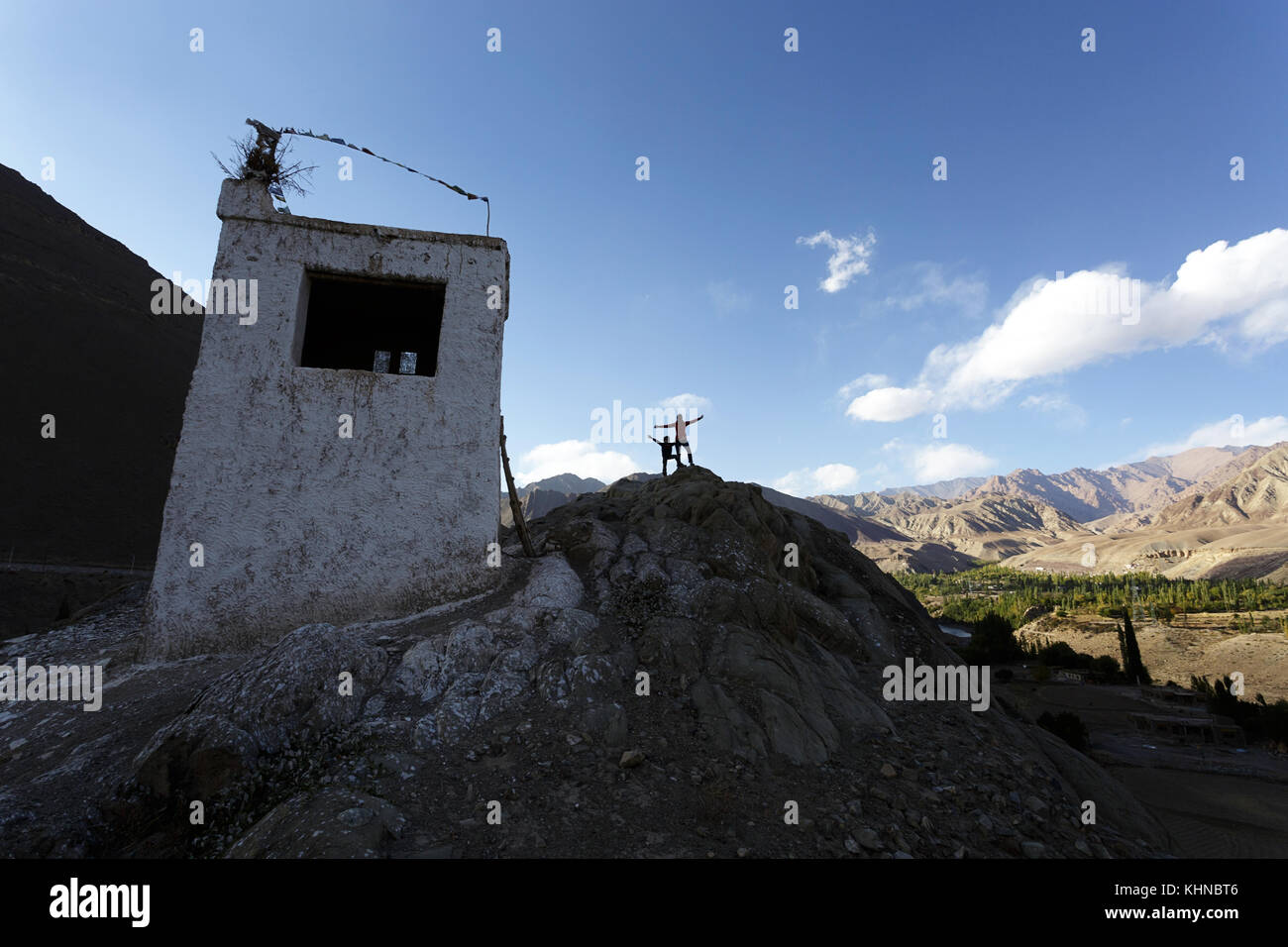 Einer weißen Frau und Jungen auf einem Hügel mit einem traditionellen tibetischen Haus, Alchi, Ladakh, Jammu und Kaschmir, Indien. Stockfoto