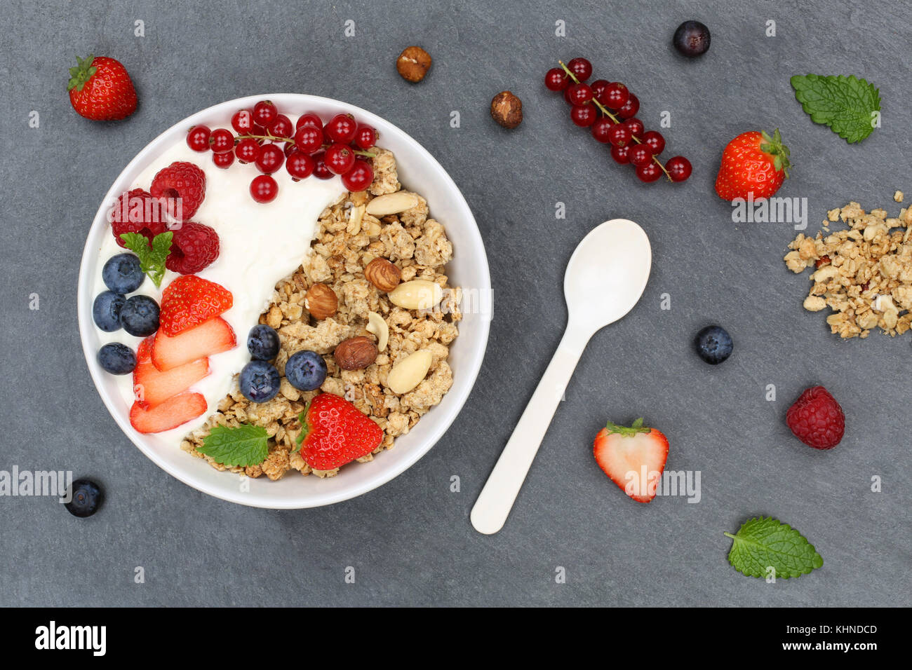 Müsli Frühstück Obst Joghurt Erdbeeren Getreide Beeren Schüssel schiefer Draufsicht von oben Stockfoto