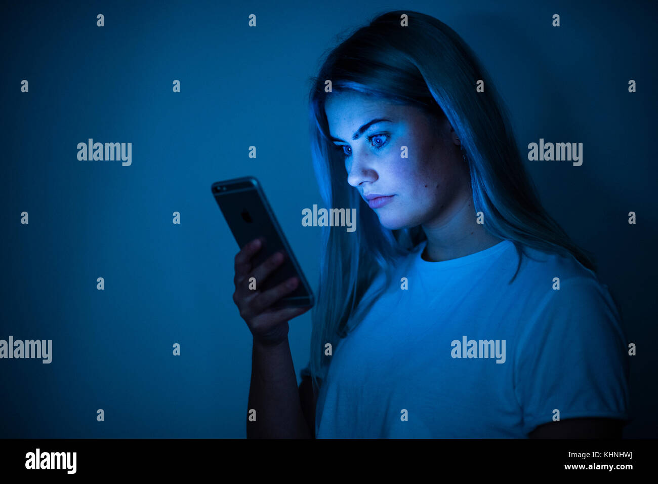 Probleme on-line: Ein junges Mädchen auf ihren Facebook Instagram snapchat e-Mails auf Ihrem Smartphone Stockfoto