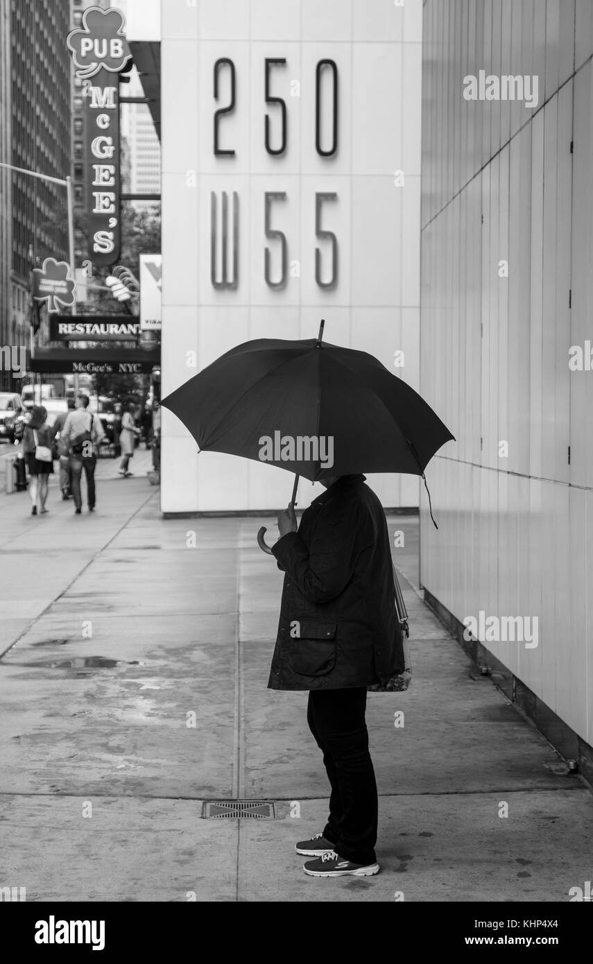 Frau in Regen in Midtown Manhattan New York Stockfoto