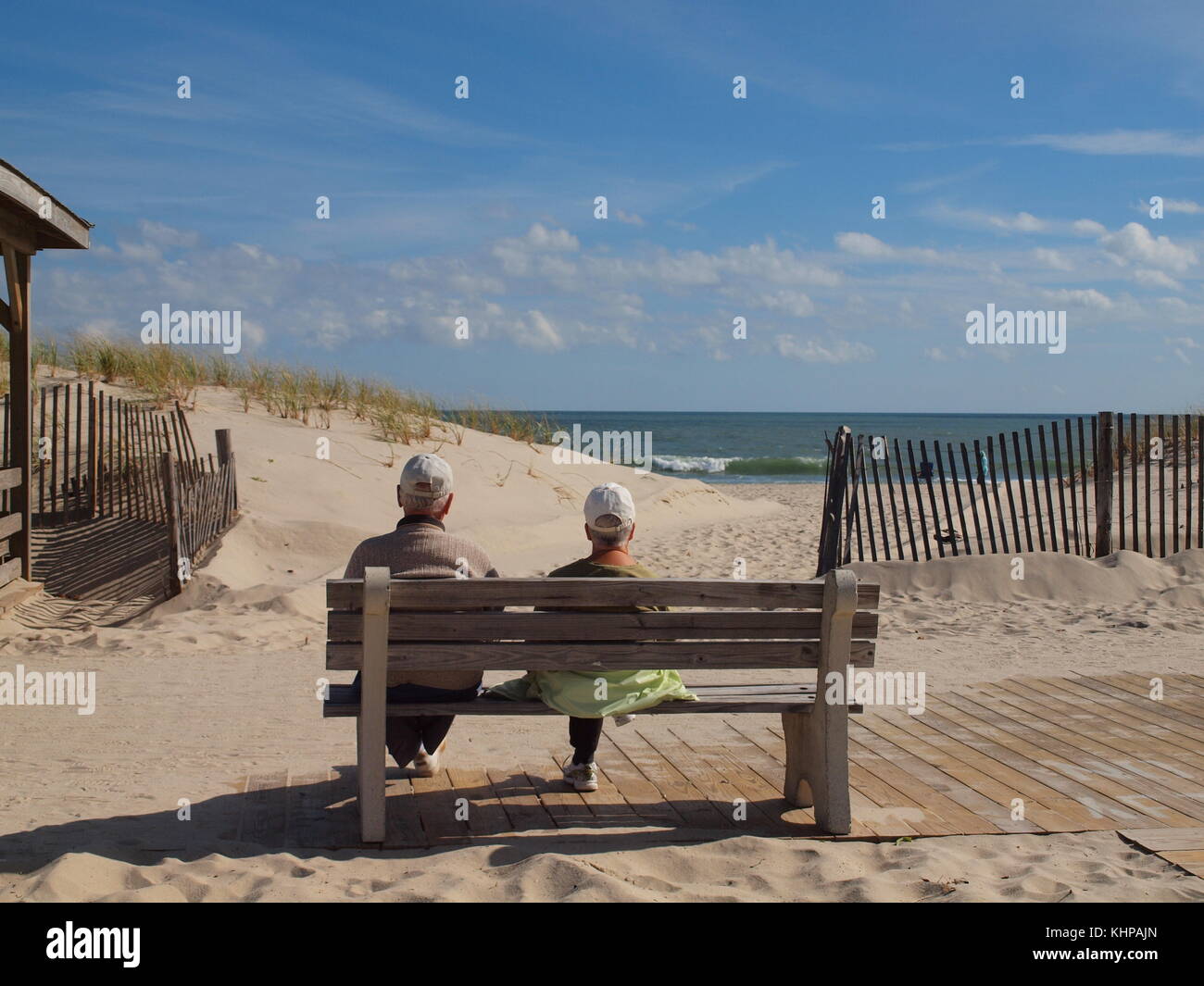 Ältere Paare geniessen die Sonne auf einer Bank am Meer in New Jersey. Stockfoto