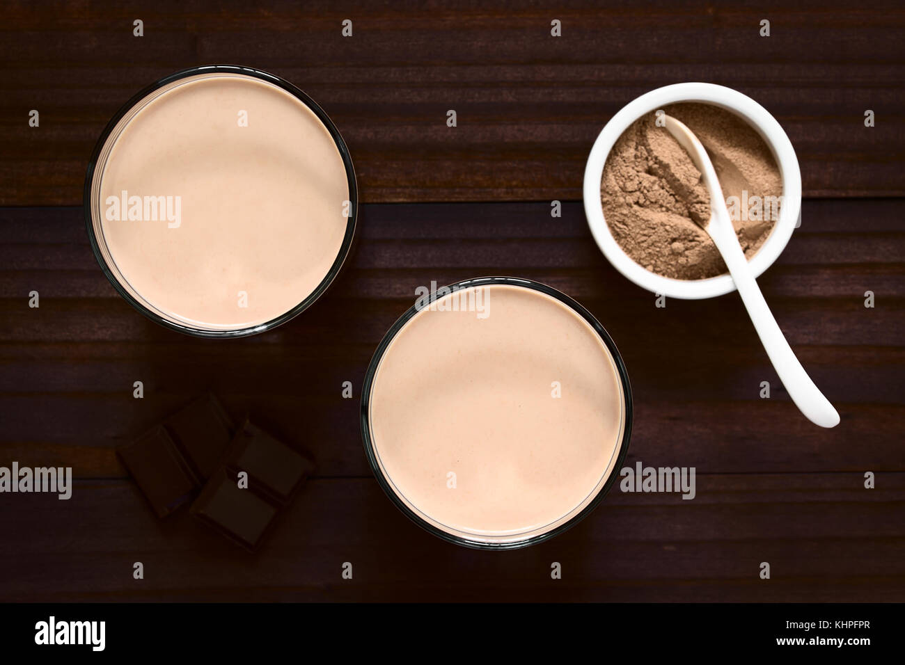 Schokolade Milch trinken in Gläsern, Schokolade oder Kakaopulver auf der Seite, Overhead fotografiert mit Tageslicht (selektive Fokus) Stockfoto