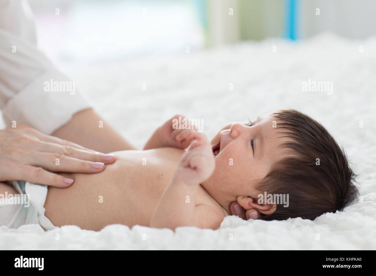 Masseur massieren den Bauch des Babys Stockfoto
