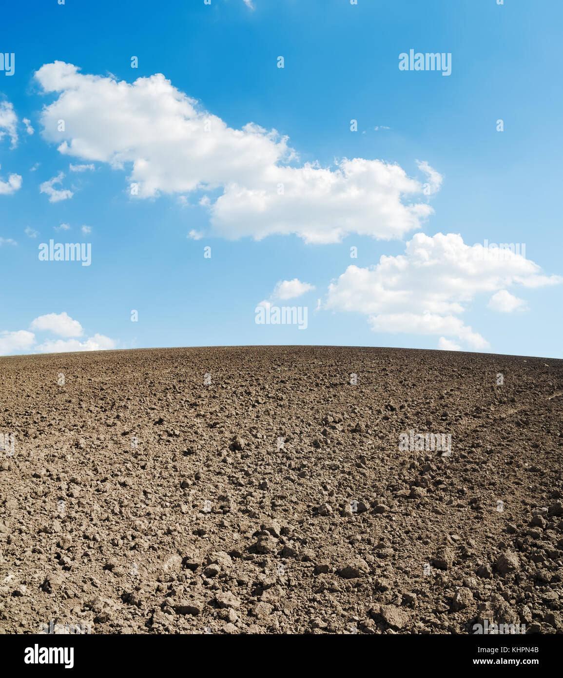 Landwirtschaftlicher Boden und blauer Himmel mit Wolken Stockfoto