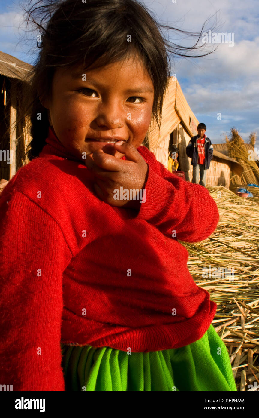 Uros, Titicaca See, Peru, Südamerika. Ein aymara Mädchen in typischen Kostümen aus dem Bereich gekleidet, der aus einem intensiven Grün Rock und einem Col Stockfoto