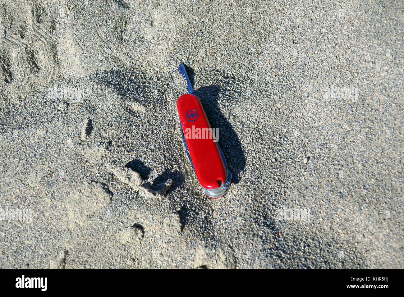 Ein Schweizer Taschenmesser ging im Sand. Stockfoto