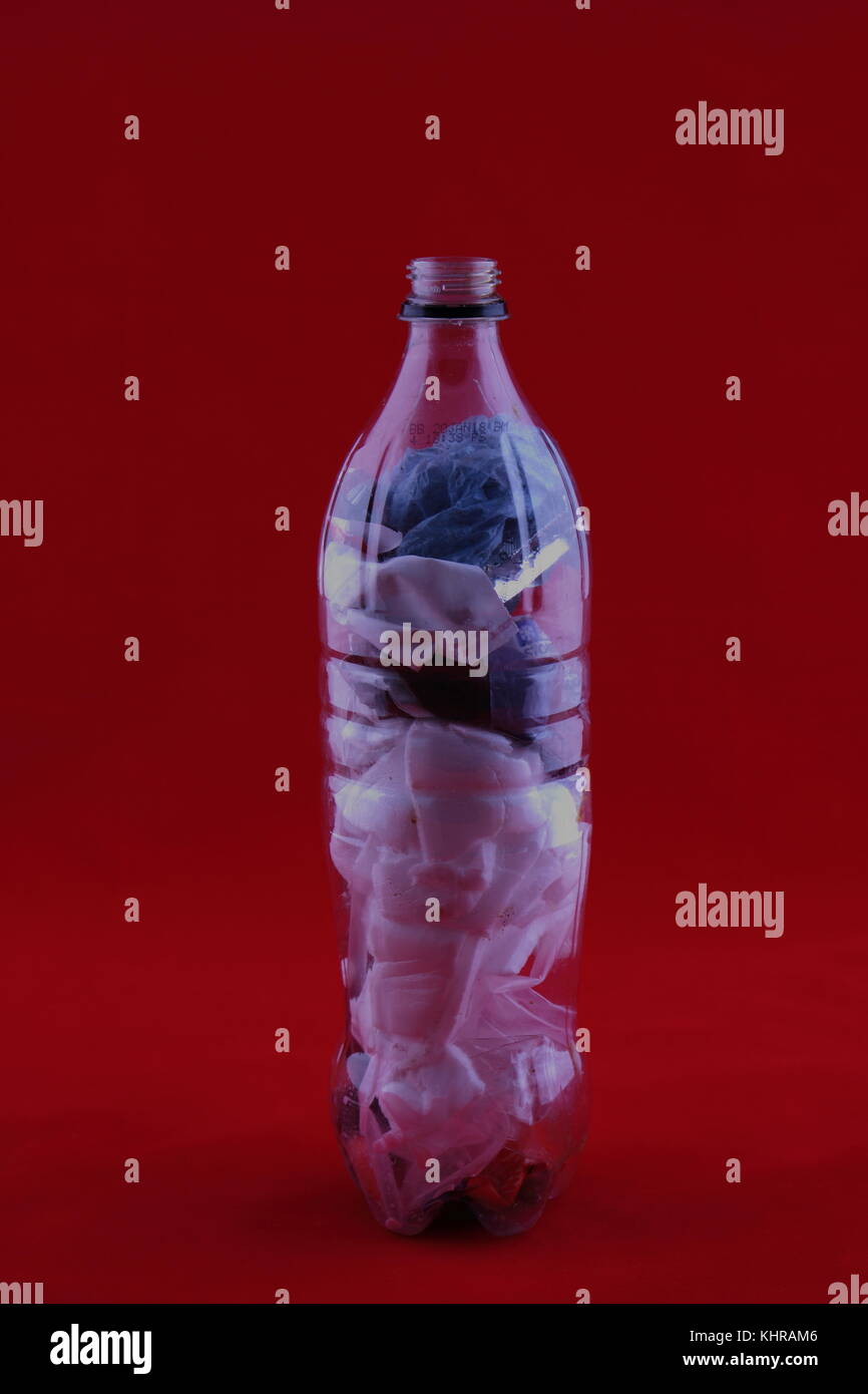 Single use Kunststoff entsorgt in eine Plastikflasche für Recycle im Hochformat mit Kopie Speicherplatz auf einem roten Hintergrund Stockfoto